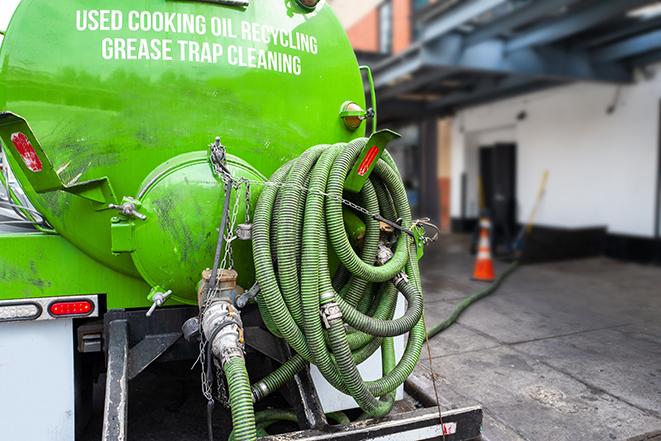 a technician pumping a grease trap in a commercial building in Springfield